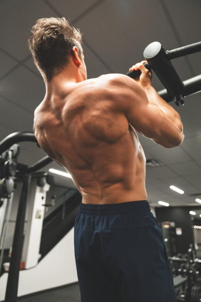 A man doing pull ups in a gym