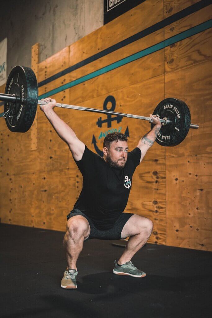 a man squats while holding a barbell